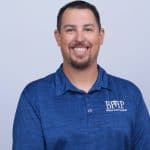 Wellness-focused professional wearing Business Health Partners branded polo shirt, representing healthcare consulting and business health solutions.